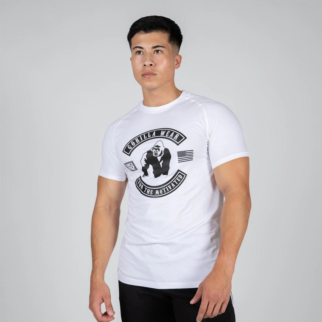 Mies yllään Gorilla Wear Tulsa T-Shirt White, valkoinen ja joustava treeni-t-paita suurella mustalla rintapainatuksella., kuva 1/3