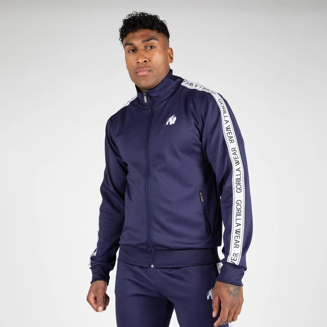 Miehen yllä tummansininen Gorilla Wear Delaware Track Jacket navy -treenitakki, jossa on valkoinen logo ja hiharaidat., kuva 4/7