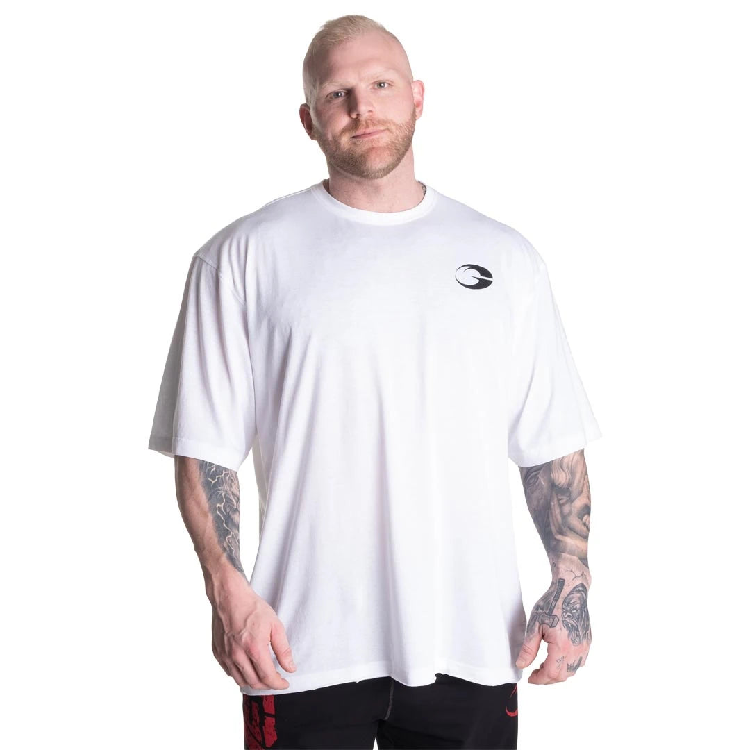 Valkoinen GASP Division Iron Tee White -treenipaita oversize-istuvuudella ja rintalogolla miehen yllä., kuva 5/7