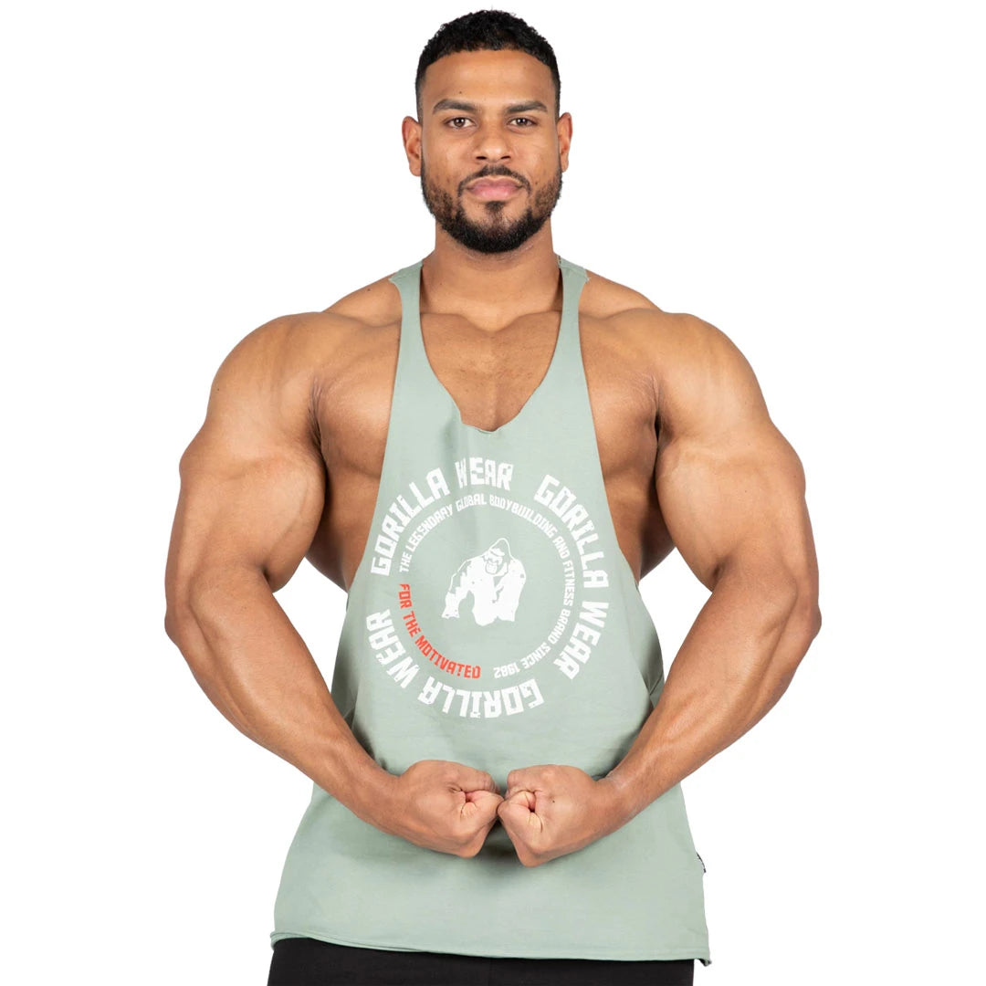 Man bär Gorilla Wear Melrose Stringer Green, ett grönt bomullslinne med stort vitt tryck och lågskurna ärmhål.