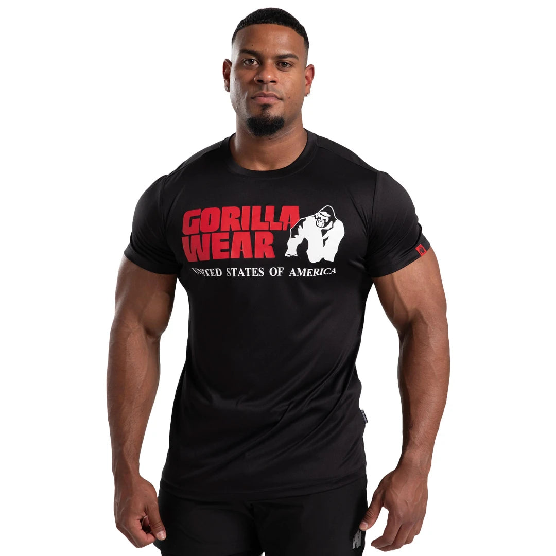 Man bär Gorilla Wear Classic Training T-Shirt Black, en svart tränings-t-shirt i funktionsmaterial med stor logotyp., bild 7 av 7