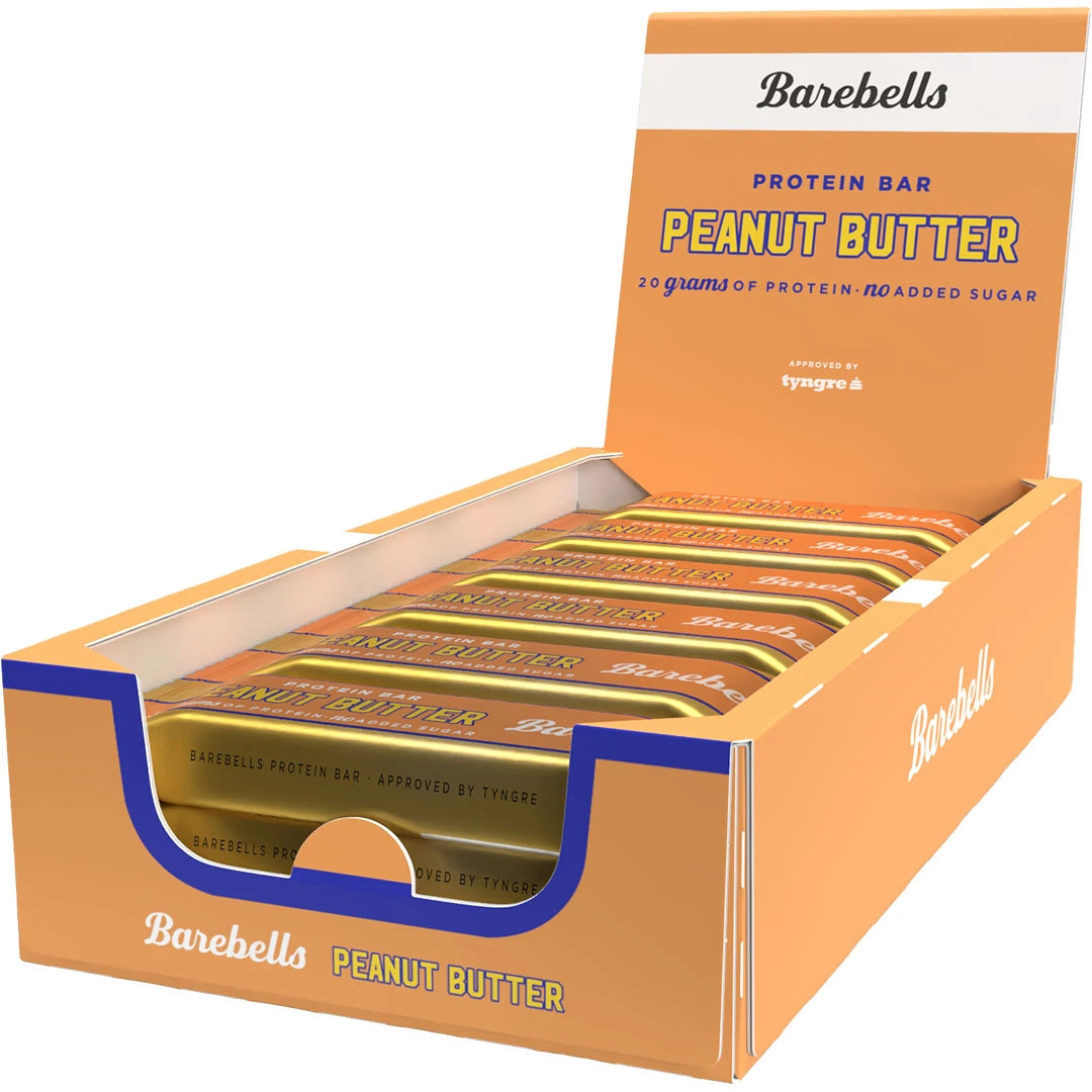 12 x Barebells Protein Bar 55 g Peanut Butter oranssi-valkoisessa esittelylaatikossa täynnä kultaisia proteiinipatukoita., kuva 1/1