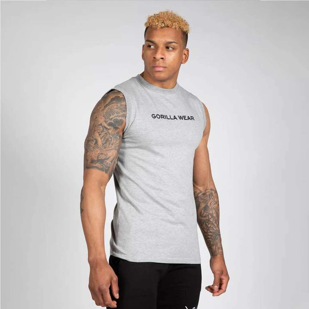 Manlig modell bär Gorilla Wear Sorrento Sleeveless T-Shirt Grey, en grå ärmlös t-shirt i stretchig bomull.