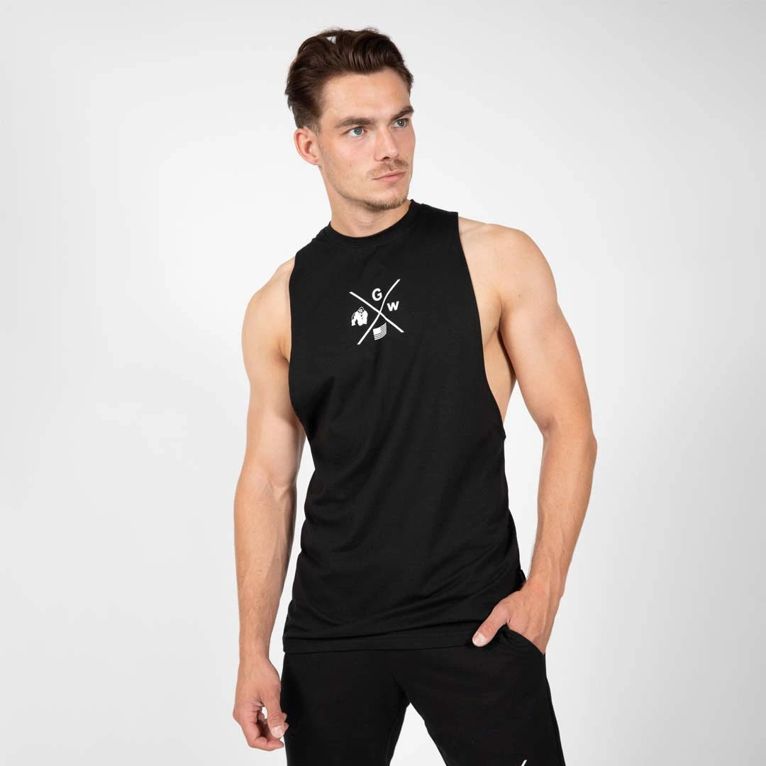 Gorilla Wear Cisco Drop Armhole Tank Top Black, ett svart bomullslinne med djupa ärmhål buret av en man., bild 3 av 6