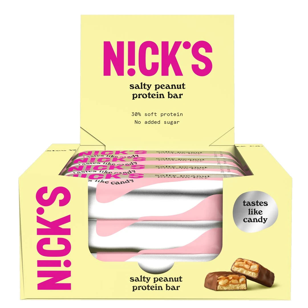 12 x NICKS Soft bar 50 g Salty Peanut SUPER DEAL i en ljusgul låda fylld med proteinbars i rosa och vita omslag.