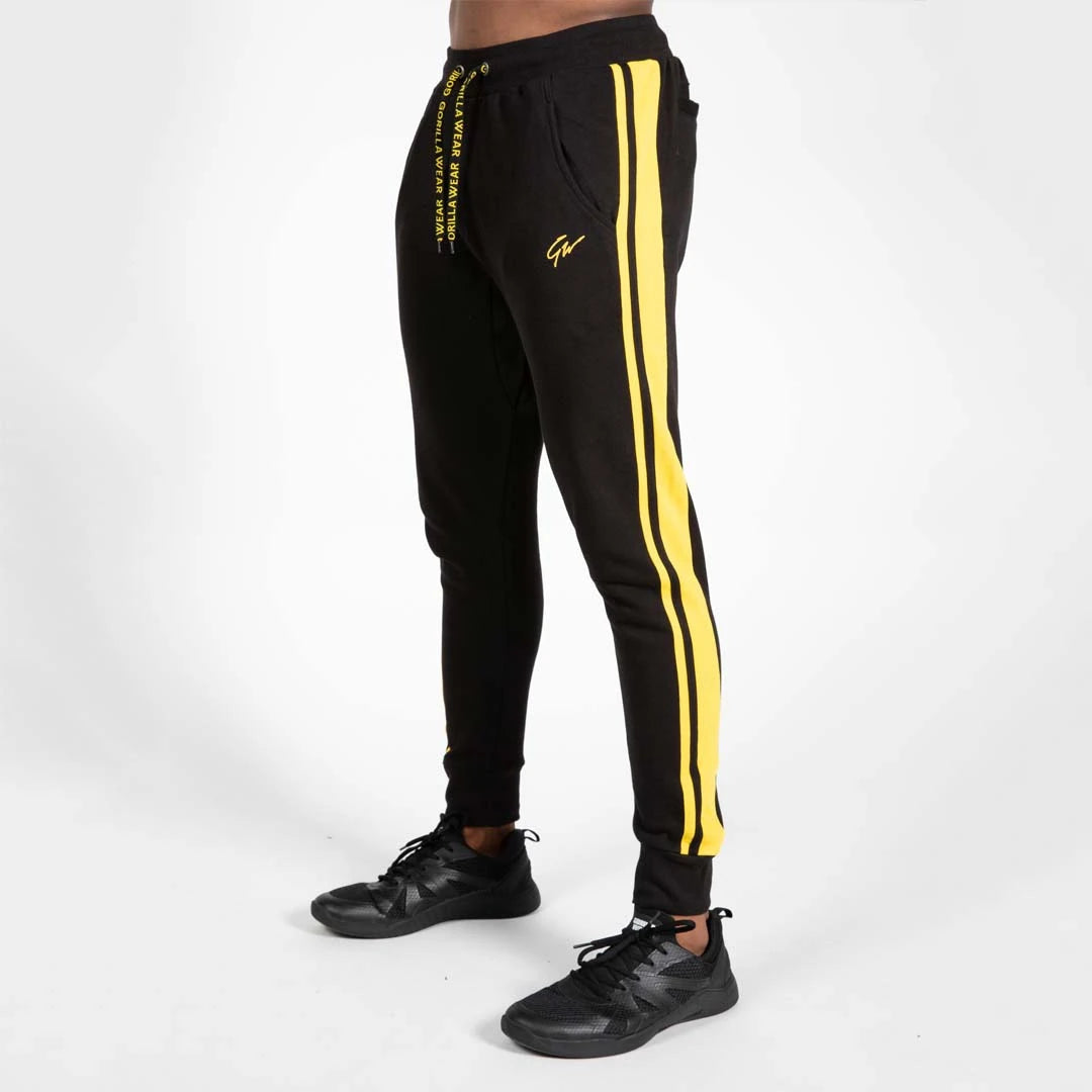 Gorilla Wear Banks Pants Black/Yellow - mustat treenihousut, joiden sivuilla on keltaiset raidat ja rento istuvuus.