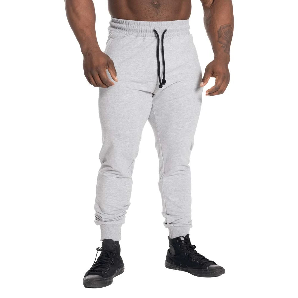 GASP Tapered Joggers Light Grey Melange ovat vaaleanharmaat kapenevat treenihousut, joissa on musta kiristysnauha., kuva 1/2