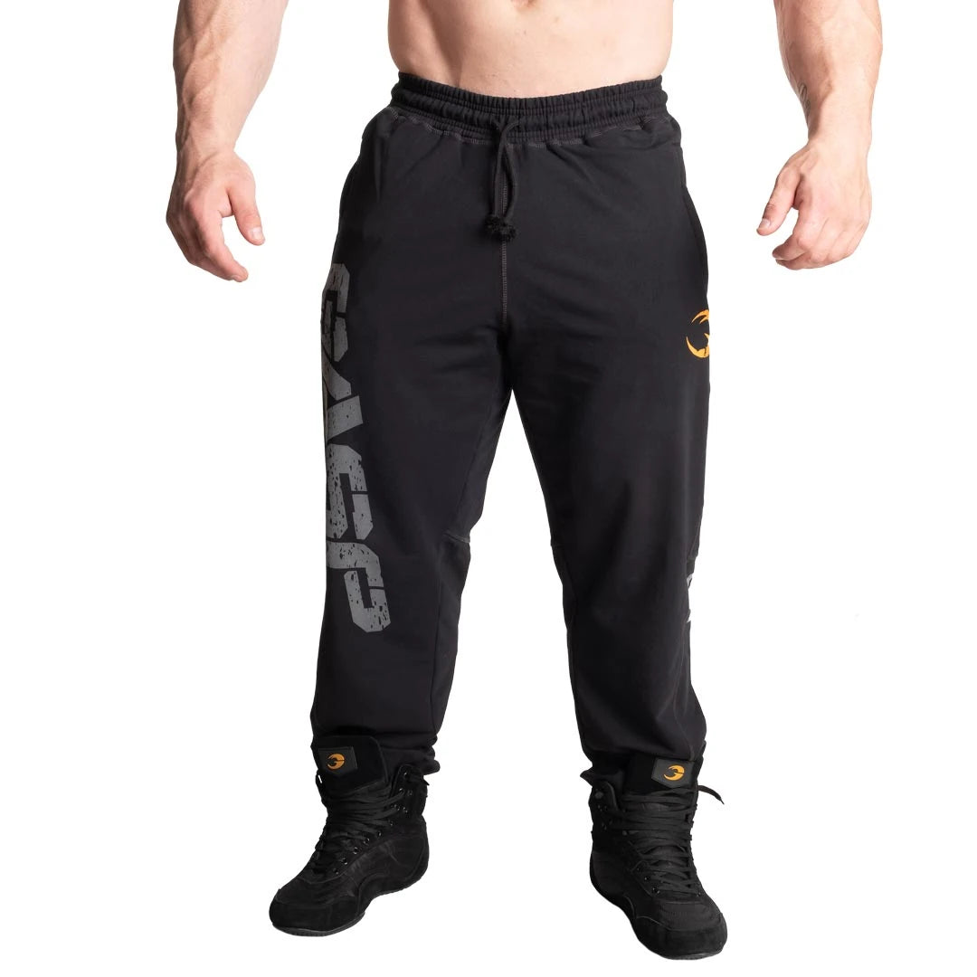 GASP Vintage Sweatpants Black -mustat kapealinjaiset treenihousut, joiden oikeassa lahkeessa on suuri harmaa logo.