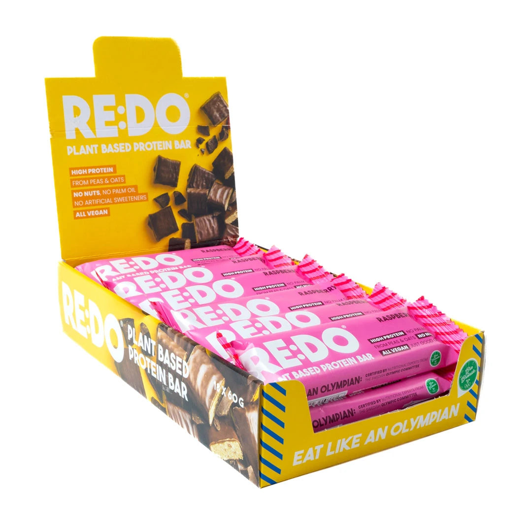 18 x REDO Bar 60 g Raspberry Rules i en gul låda med rosa bars.